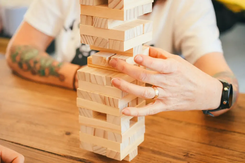 Person stacking wooden blocks at a table