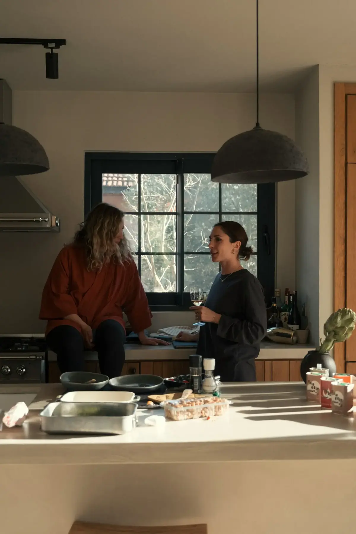 Two women discussing household tasks in a kitchen
