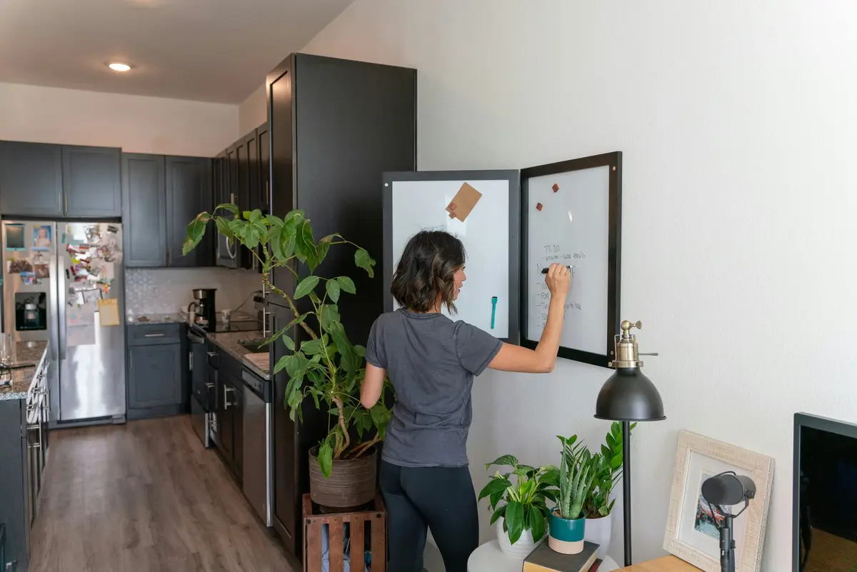 Person using a wall-mounted planning board in a kitchen