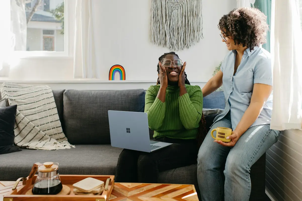 Two women talking on a living room sofa