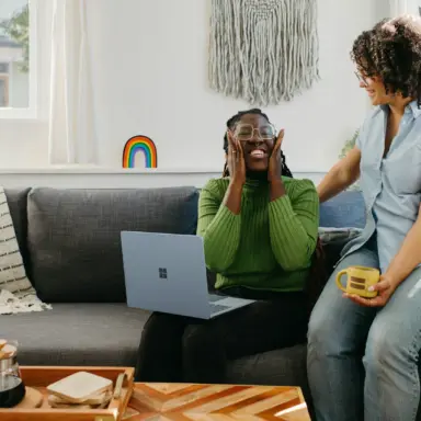 Two women talking on a living room sofa