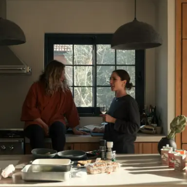Two women discussing household tasks in a kitchen