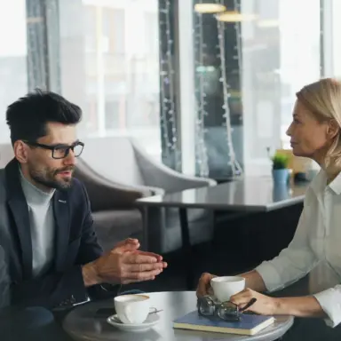 Two adults sitting across a café table in conversation