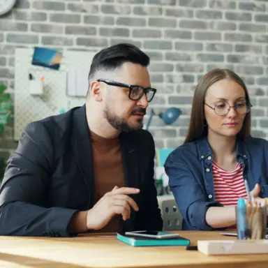 Two people reviewing a laptop together at a desk
